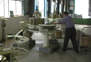 Well dressed worker putting wilted tea leaves into the rolling machine